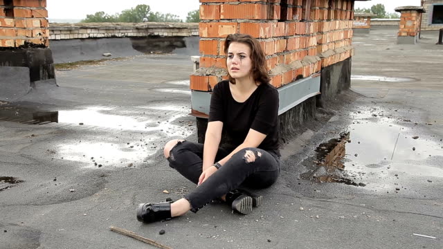 Teengirl-in-Depression-sitzt-auf-dem-Dach-eines-Gebäudes