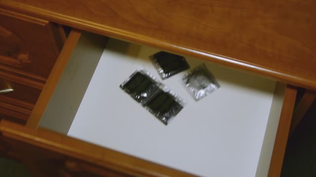 A-man-takes-a-condom-from-the-bedside-table.-Protection-against-aids-and-pregnancy.