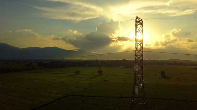 Fliegen-nach-der-hohen-Spannung-Strom-Turm-mit-Sonnenuntergang