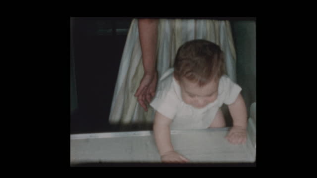 década-de-1950-la-madre-enseña-a-bebé-a-subir-pasos-atrás