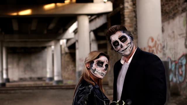 Halloween-loving-couple-in-costumes-of-skeletons-and-sugar-skull-make-up.