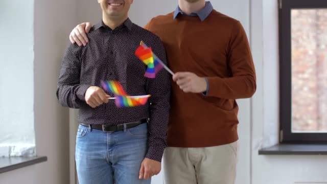 männlichen-Partner-mit-gay-Pride-Regenbogen-Fahnen-zu-Hause