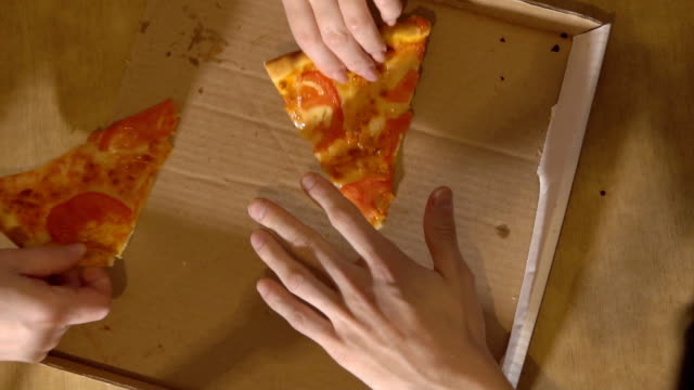 Company-of-three-people-gets-to-the-last-two-slices-of-pizza