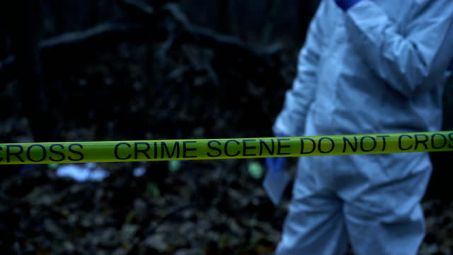 Crime-scene-in-the-woods,-murder-site,-forensic-expert-collecting-evidence