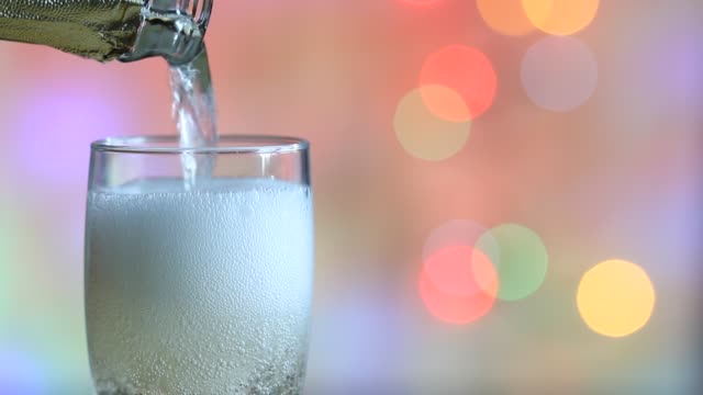 Glas-Champagner-und-bunten-unscharf-gestellt-Silvester-Party-Hintergrund