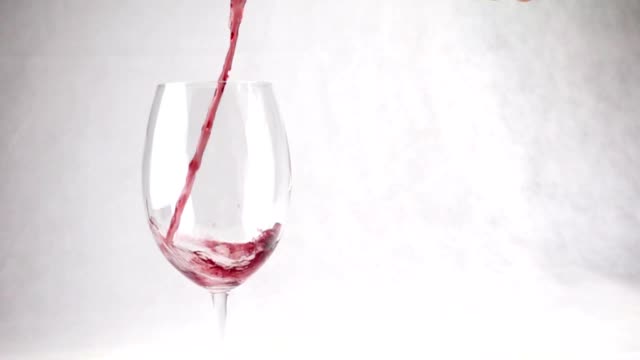 Wein-in-ein-Glas-mit-Tropfen-in-Zeitlupe-gießen