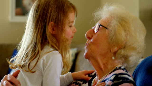 Großmutter-und-Enkelin,-küssen-einander-im-Wohnzimmer-4k