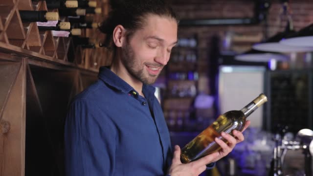 Handsome-Man-Holding-Bottle-Of-Wine-At-Wine-Cellar