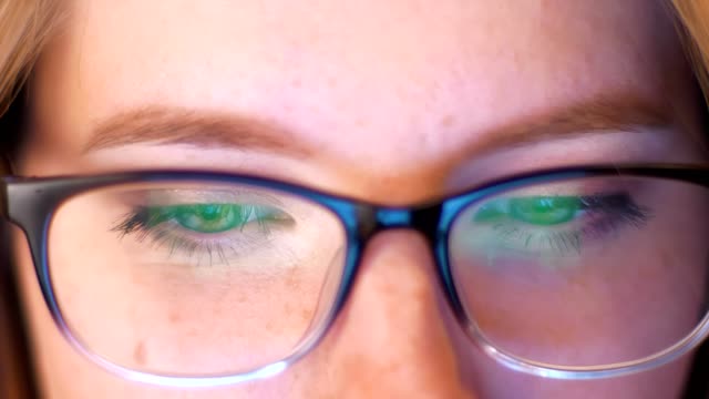 Nahaufnahme-Augen-in-Spartakeln-mit-Blick-auf-grüne-Leinwand,-während-in-Gläsern-reflektiert-wird,-schöne-kaukasische-Smart-Blondine-konzentriert-ist