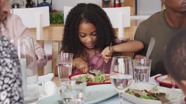 Multi-Generation-Family-sitzt-am-Tisch-zu-Hause-Freude-am-Essen-zusammen