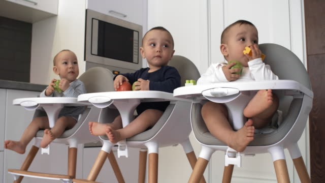 Curious-Triplets-Biting-on-Apples-and-Watching-Something