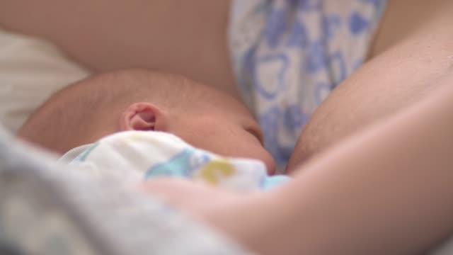 Müde-und-verschlafene-Mutter-stillen-Neugeborenen