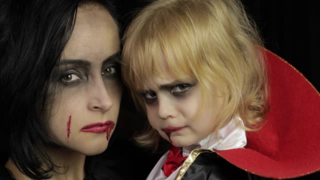 Frau-und-Kind-dracula.-Halloween-Vampir-Make-up.-Kind-mit-Blut-im-Gesicht