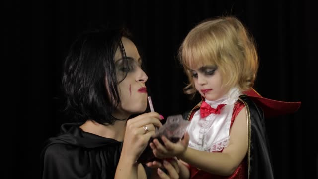 Woman-and-child-dracula.-Halloween-vampire-make-up.-Kid-with-blood-on-her-face