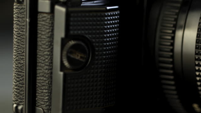 4K-video-de-rollos-de-película-de-fotos-antiguas,-casete-y-cámara-retro,-enfoque-selectivo