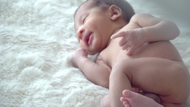 4K-Tiro-mediano-de-relajante-adorable-pequeño-bebé-recién-nacido-asiático-hijo-durmiendo-en-la-cama-blanca-en-el-dormitorio-de-casa.-Lindo-cuidado-de-la-salud-del-bebé-recién-nacido-inocente-y-concepto-de-piel-sensible.