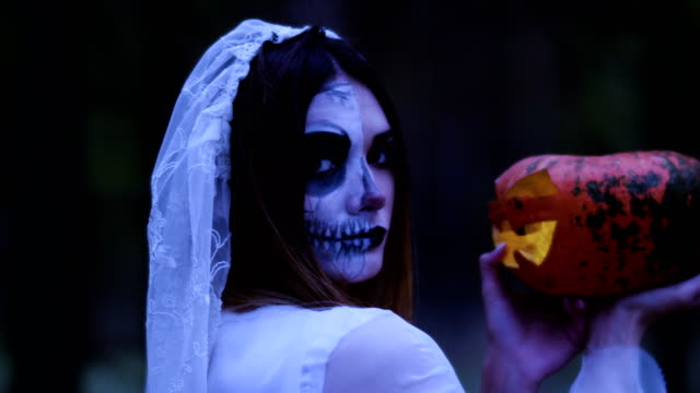 Halloween.-The-woman-holding-in-the-arms-a-pumpkin-with-a-burning-wax-candle.-4K
