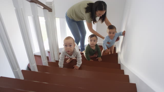 Asiatische-Baby-Triplets-und-Mama-auf-Treppe