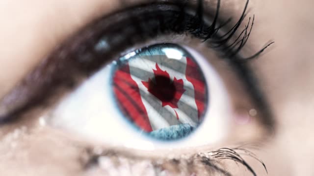 Frau-blaues-Auge-in-Nahaufnahme-mit-der-Flagge-von-Kanada-in-Iris-mit-Windbewegung.-Videokonzept