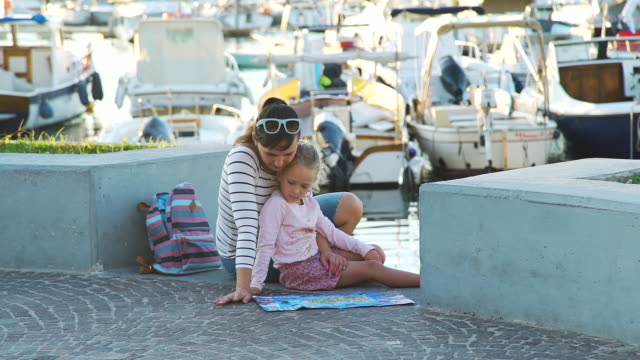 Frau-mit-Tochter-Blick-auf-eine-Karte-in-der-Nähe-von-Marina