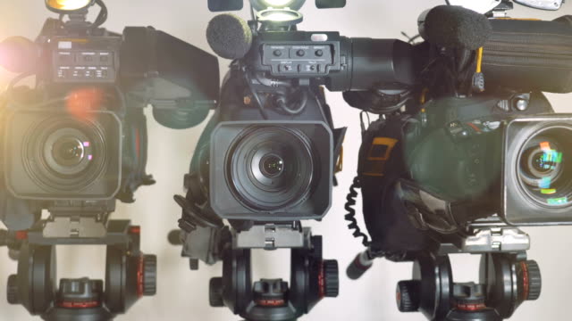 Ein-Zoomen-Schuss-auf-drei-hell-beleuchteten-Videokameras.