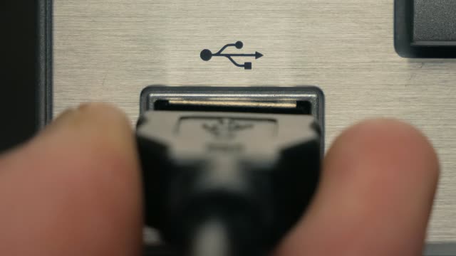 The-man-connects-black-USB-cable.-Close-up