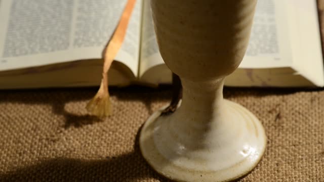 Biblia-con-cáliz-de-vino,-resbalando,-tilt