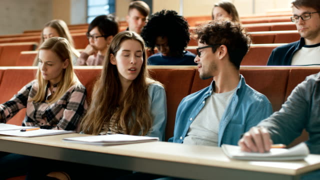 Boy-and-a-Girl-Students-Talking-to-Each-other-in-the-University-Classroom,-they're-Classmates-Listen-to-a-Lecture.