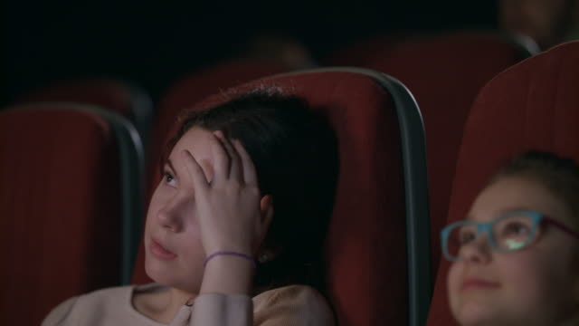 Teenager-Mädchen-Film-im-Kino-mit-jüngeren-Schwester