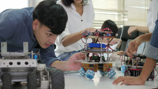 Team-von-Elektronik-Ingenieur-zusammen-arbeiten,-gemeinsam-an-einem-Projekt-arbeiten,-Roboter-zu-bauen.-Menschen-mit-Technologie-oder-Innovation-Konzept.