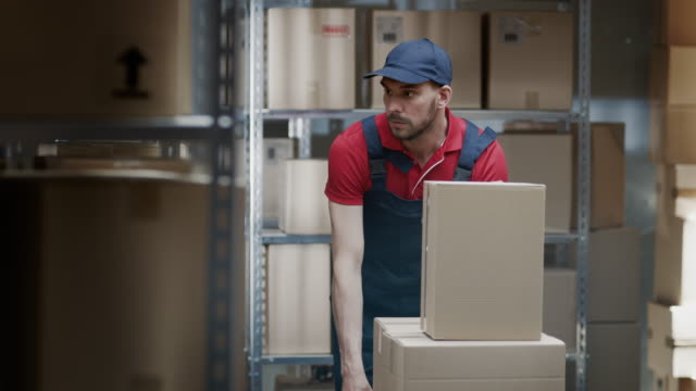 Almacén-el-trabajador-recoge-la-orden-por-tomar-cajas-de-cartón-y-paquetes-de-la-plataforma-y-ponerlos-en-un-carro.
