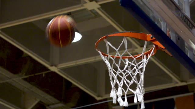 People-training-basketball-free-throw-and-missing.-Basketball-net-close-up.-Flat-plane.-Low-angle-shot