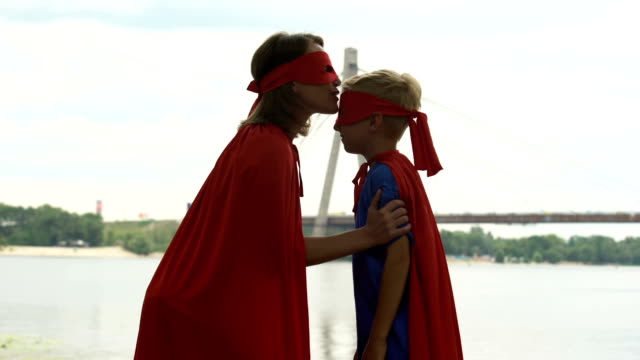 Mutter-in-Superhelden-Kostüm-küsst-Sohn-Stirn,-umarmen,-Unterstützung-bei-der-Anfänge