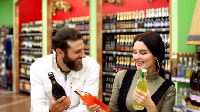 A-beautiful-couple-chooses-champagne-and-liquor-in-a-supermarket-and-dance.