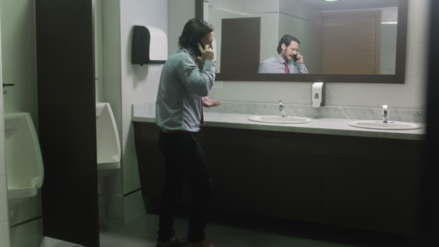 Furious-Business-Man-Screaming-On-Cell-Phone-In-Office-Restroom