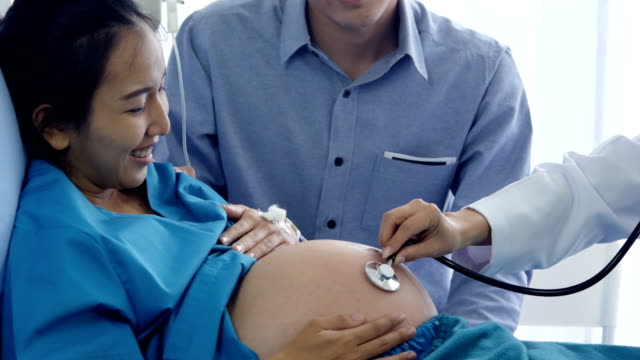 Close-up-doctor-hand-using-stethoscope-to-listen-baby-inside-pregnant-woman-belly.-People-with-healthcare-and-medical-concept.