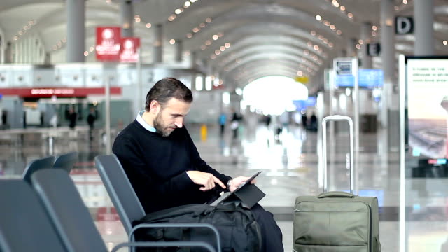 Passagier-mit-seinem-Tablet-am-Abflug-Lounge-am-Flughafen