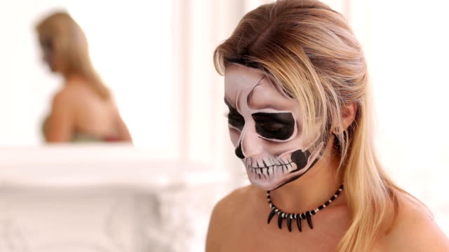 Young-blonde-with-a-bouquet-of-black-flowers-and-makeup-in-the-form-of-skeleton.