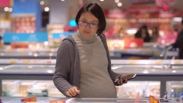 Pregnant-asian-woman-shopping--in-the-supermarket