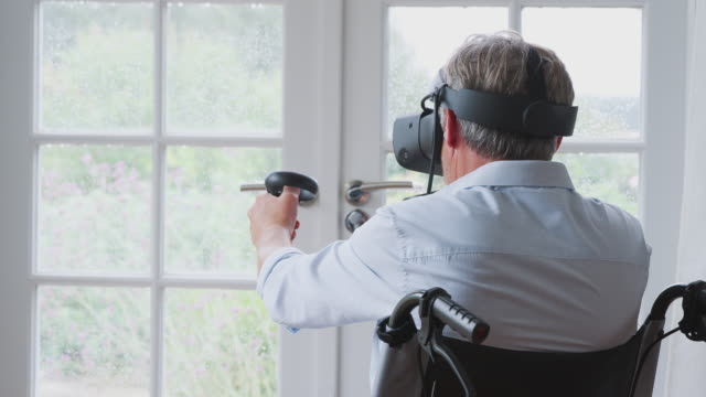 Hombre-discapacitado-senior-en-silla-de-ruedas-en-casa-usando-auriculares-de-realidad-virtual-sosteniendo-controladores-de-juego