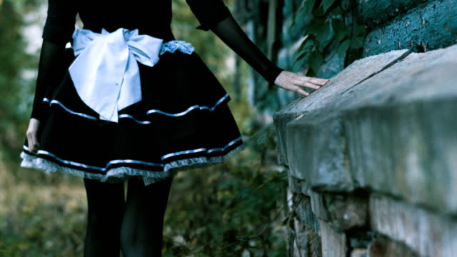 Halloween.-Back-of-the-young-woman-going-along-the-wooden-abandoned-house.-4K