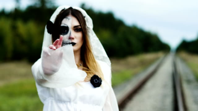 Ein-Porträt-der-jungen-Frau-mit-gruseligem-Make-up-für-Halloween-in-einem-Brautkleid.-4K