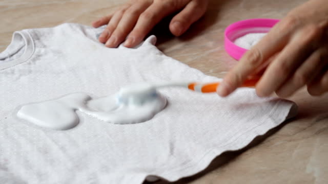 Mutter-zu-reinigen-Flecken-auf-Kinderkleidung-von-Süßigkeiten-mit-Hilfe-von-Fleckenentferner-und-Waschpulver,-Nahaufnahme,-Fleckenentfernung,-Hygiene