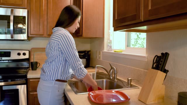 vista-lateral-joven-mujer-asiática-lavando-platos