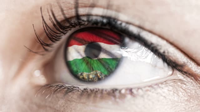 Frau-grünes-Auge-in-Nahaufnahme-mit-der-Flagge-von-Ungarn-in-Iris-mit-Windbewegung.-Videokonzept