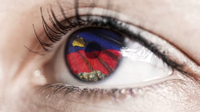 woman-green-eye-in-close-up-with-the-flag-of-Liechtenstein-in-iris-with-wind-motion.-video-concept
