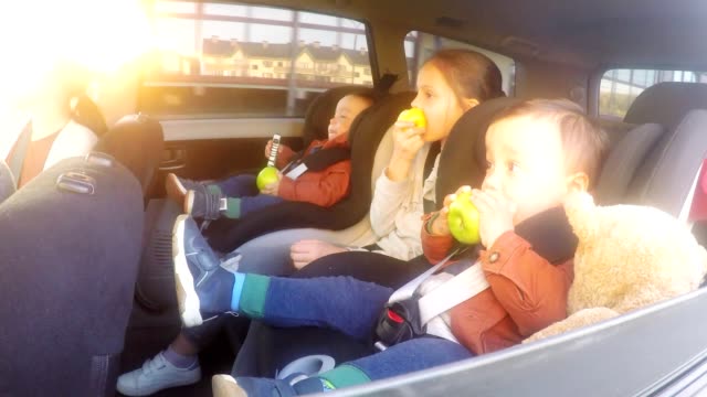 Entzückende-Kinder-essen-Äpfel-im-Auto