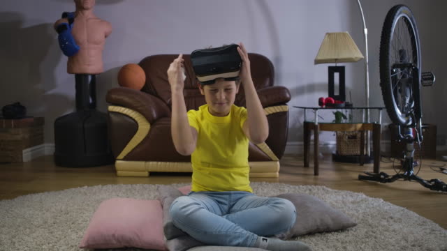 Porträt-von-männlichen-kaukasischen-Teenager-auf-VR-Headset-und-mit-Fernbedienung,-um-das-Spiel-einzuschalten.-Kind-versucht-auf-Gerät-zu-Hause.-Virtuelles-Headset,-Online-Spiele,-3D-Realität.-Kino-4k-ProRes-HQ.