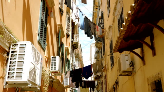 Clean-clothes-and-linen-hanging-on-a-clothesline-to-dry-outdoors-in-streets.-4K