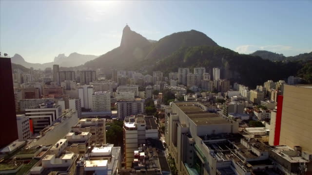 Rio-de-Janeiro-aéreo:-mover-lateralmente-a-través-de-playa-Botafogo-con-Cristo-Redentor-en-el-fondo-y-edificios-de-gran-altura-en-primer-plano-cercano